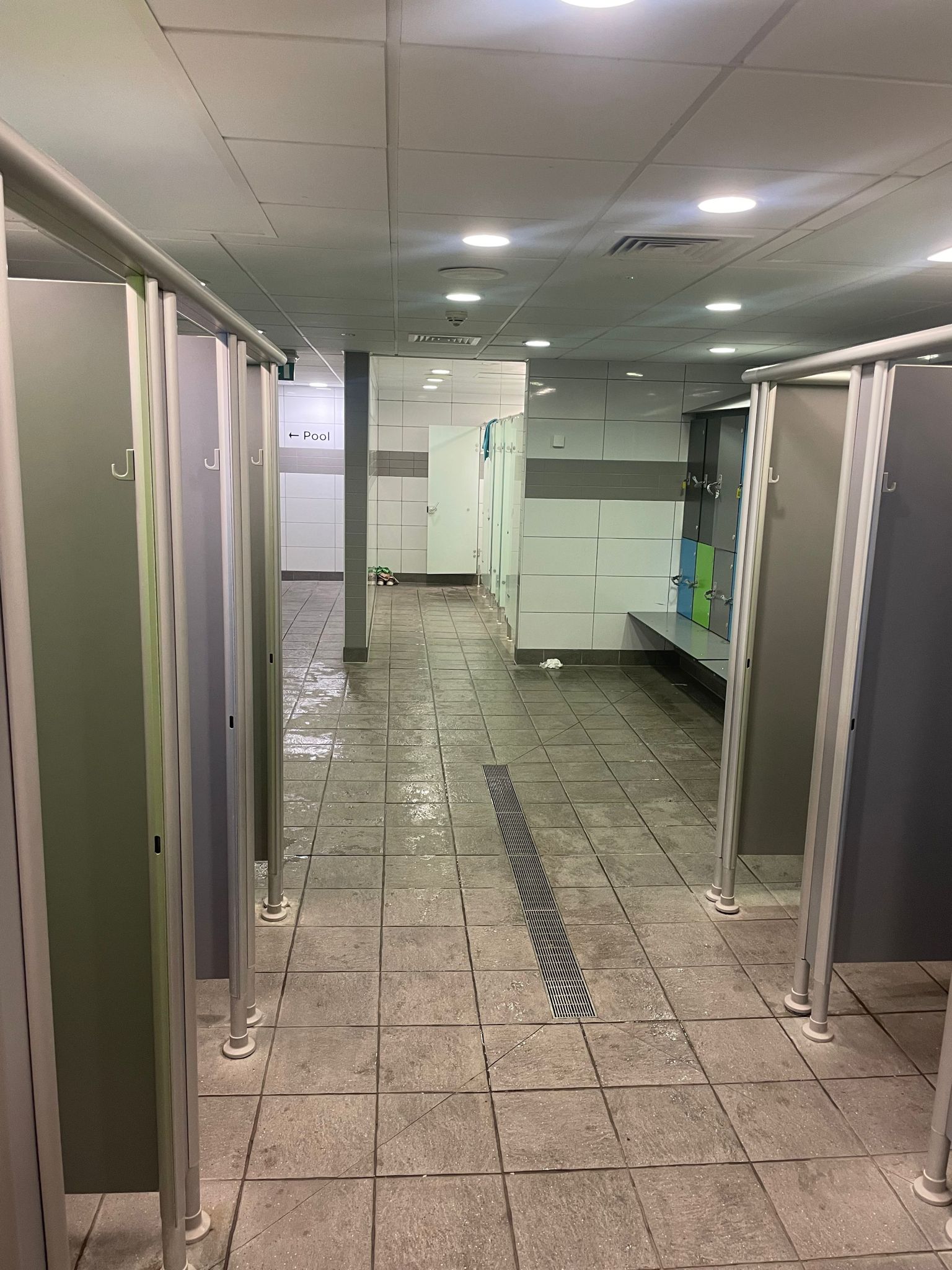single sex changing room with benches in group change and changing cubicles
